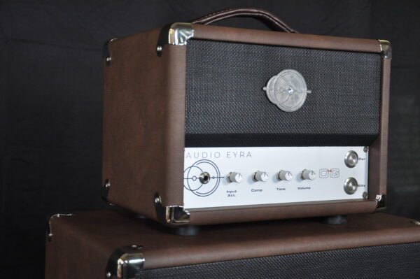 A brown and silver guitar amp sitting on top of two other speakers.